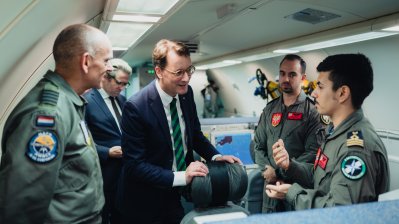 Ministerpräsident Hendrik Wüst spricht in einem Flugzeug mit Soldaten