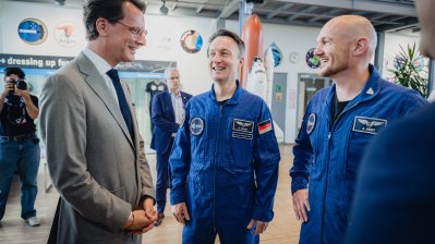 MP Wüst und zwei Astronauten unterhalten sich