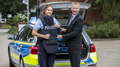 Minister Ralf Jäger stellt mit Polizeibeamtin die neue Hightech-Schutzweste vor