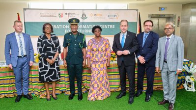 Vier Männer und zwei Frauen stehen vor einem bunt geschmückten Tisch