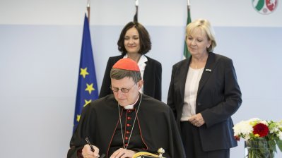 Kardinal Woelki beim Eintrag in das Gästebuch der Landesregierung