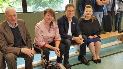 Staatssekretärin Andrea Milz sitzt gemeinsam mit den Vertretern der Graf Recke Stiftung und des Stadtsportbundes Düsseldorf auf einer Sportbank.