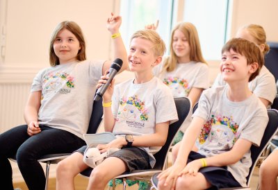 Kinder-Pressekonferenz: Ein Kind stellt eine Frage