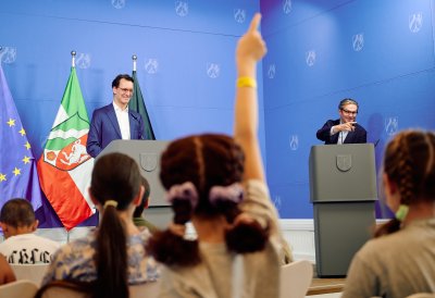 Kinder-Pressekonferenz: Kinder heben den Arm um eine Frage zu stellen