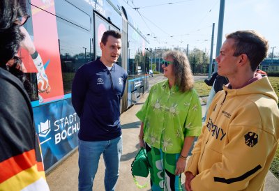 Staatssekretärin Milz steht vor der Straßenbahn und unterhält sich