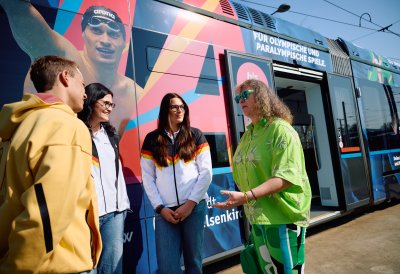 Staatssekretärin Milz steht vor der Straßenbahn und unterhält sich