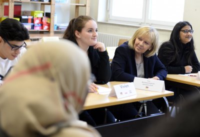 Ministerpräsidentin Hannelore Kraft sitzt zwischen Schülerinnen und Schülern im Klassenraum