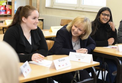 Ministerpräsidentin Hannelore Kraft sitzt zwischen Schülerinnen und Schülern im Klassenraum