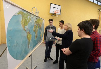 Ministerpräsidentin Hannelore Kraft mit Schülern zeigend vor einer Weltkarte