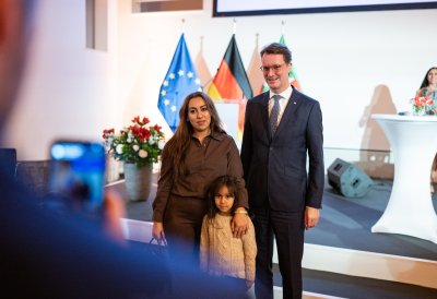 MP Wüst und Neubürger posieren für ein Foto