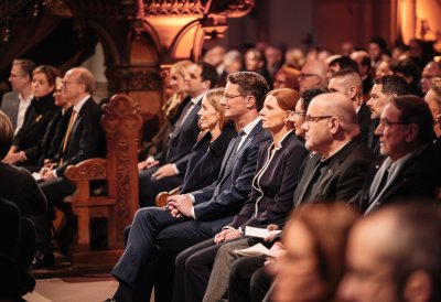 MP Wüst und Gäste sitzen im Publikum