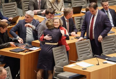 Ministerin Schäffer wird von Kabinettmitgliedern auf der Regierungsbank umarmt