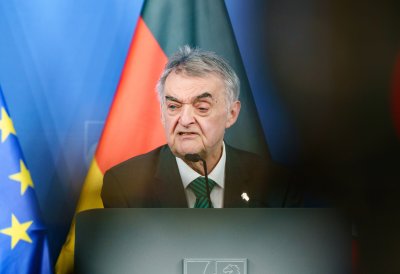 Minister Reul spricht an einem Rednerpult vor Flaggen