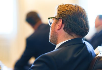 Besprechungssituation in einem festlichen Raum, Staatssekretär Wiermer hört zu