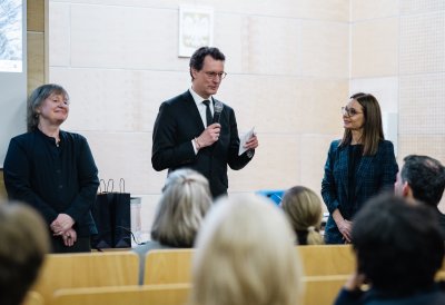 MP Wüst steht in einem Hörsaal und hält eine Ansprache