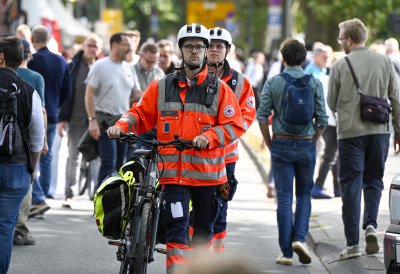 Sanitäter schieben ein Fahrrad auf der Meile