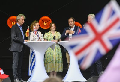 Europaminister Liminski spricht bei einer Podisumsdiskussion - im Vordergrund unscharf die UK-Flagge