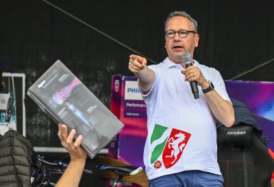 Justizminister Limbach moderiert auf einer Bühne eine Gewinnshow