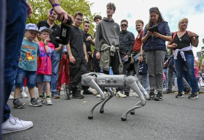 Ein Roboterhund demonstriert seine Fähigkeiten, Zuschauer stehen im Kreis
