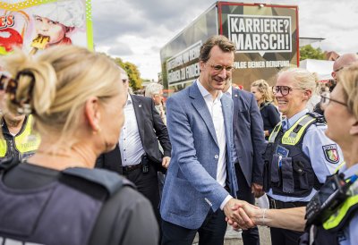 MP Wüst begrüßt auf der Meile eine Polizeibeamtin