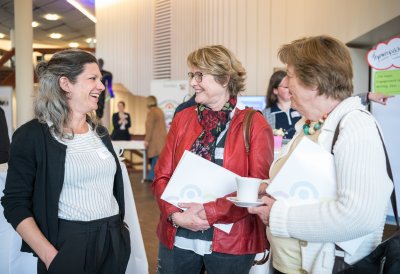 Drei Damen stehend im Gespräch.