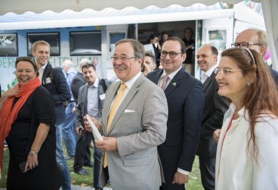 Ministerpräsident Armin Laschet und Umweltministerin Ursula Heinen-Esser stehen an einem Stand und lachen