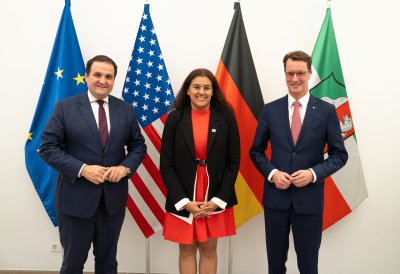 Die Generalkonsulin steht neben dem Ministerpräsidenten und dem Minister Liminski vor den Flaggen der EU, USA, Deutschlands und des Landes Nordrhein-Westfalens.