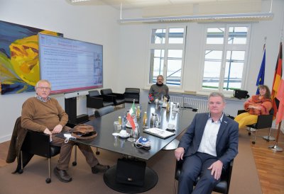 Staatsekretärin Milz in einem Besprechungsraum mit 3 Herren an einem schwarzen Besprechungstisch..
