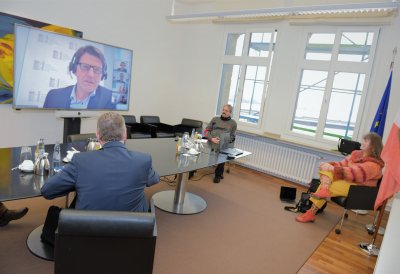 Staatssekretärin Milz nimmt mit 3 Herren in einem Besprechungsraum an einer Videokonferenz teil.
