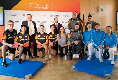 Ministerpräsident Armin Laschet steht mit einem Tischtennisspieler-Team zusammen für ein Portraitbild.