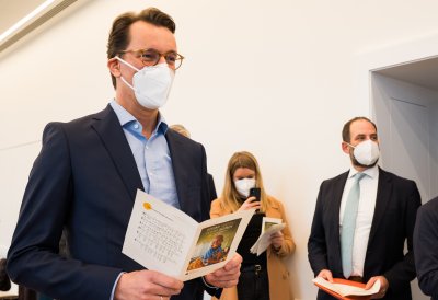 Ministerpräsident Hendrik Wüst schaut in das Gesangsheft