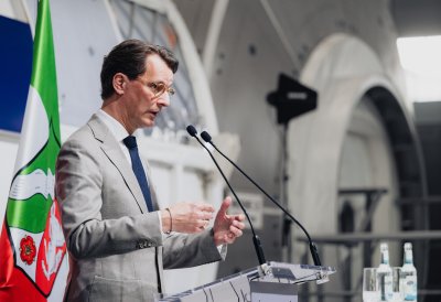 MP Wüst während seiner Rede vor einer Raumfahrtkapsel