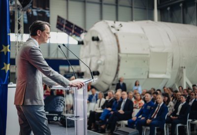 MP Wüst während seiner Rede vor einer Raumfahrtkapsel