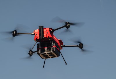 Eine mit einer Lieferung beladene Drohne fliegt in der Luft