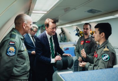 Ministerpräsident Hendrik Wüst spricht in einem Flugzeug mit Soldaten