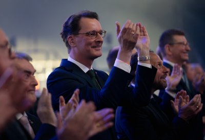 Ministerpräsident Wüst und andere menschen applaudieren
