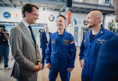 MP Wüst und zwei Astronauten unterhalten sich