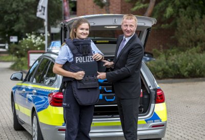 Minister Ralf Jäger stellt mit Polizeibeamtin die neue Hightech-Schutzweste vor