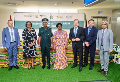 Vier Männer und zwei Frauen stehen vor einem bunt geschmückten Tisch