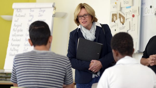 Minsterin Schäfer steht vor einer Klasse Jugendlicher