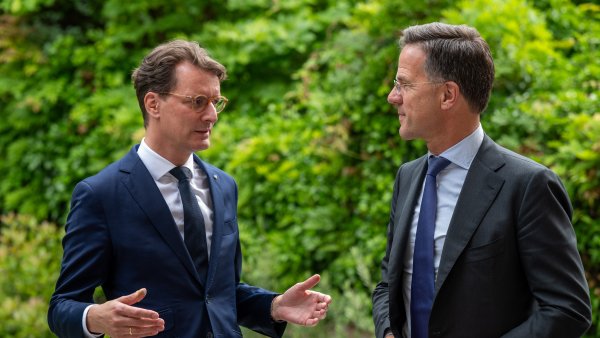 Ministerpräsident Wüst und NATO-Generalsekretär Mark Rutte im Gespräch vor grünem Hintergrund