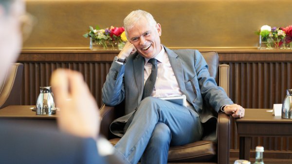 Besprechungssituation in einem festlichen Raum, der Doyen lacht