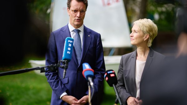 MP WÜst und MP Schwesig geben eine Statement auf einer Wiese, im Hintergrund ein Segelboot