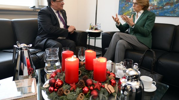 Ministerpräsident Armin Laschet im Gespräch mit der Botschafterin Frankreichs, vorne auf dem Tisch ein Adventskranz mit drei brennenden Kerzen.