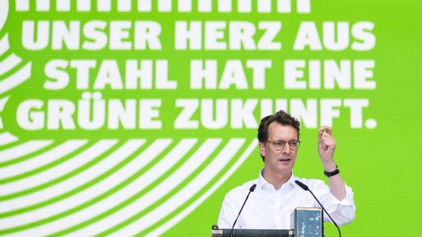 Ministerpräsident Hendrik Wüst hält eine Rede vor einer Wand mit dem Text "Unser Herz aus Stahl hat eine grüne Zukunft."