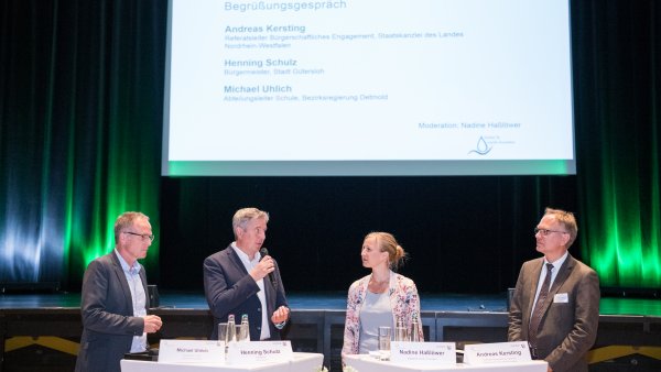 Ein Frau und drei Männer in einer Diskussionsrunde auf einer Bühne. Von links nach rechts: Herr Michael Uhlich, Herr Henning Schulz, Frau Nadine Haßlöwer und Herr Andreas Kersting.