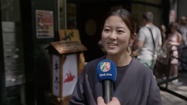 Eine japanische Frau wird auf der Straße befragt
