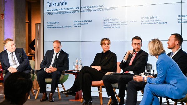 Ein spricht auf einem podium, neben ihm Ministerin Neubaur