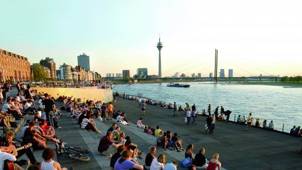 Sitzende Menschen auf Treppe am Rhein