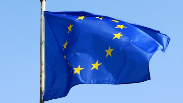 EU-Flagge weht im Wind - Blaue Flagge mit gelben Stermen im Kreis.